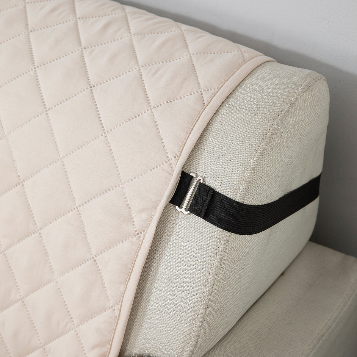 Beige quilted sofa cover with anti slip elastic strap